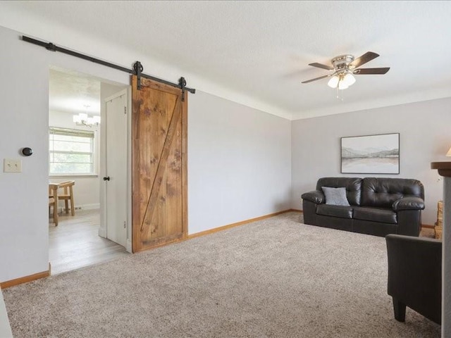 8 25th Ave SW, Cedar Rapids, IA 52404 - carpeted living room with a barn door, a chandelier, and a ceiling fan