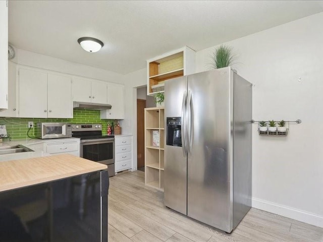 8 25th Ave SW, Cedar Rapids, IA 52404 - kitchen with appliances with stainless steel finishes, open shelves, under cabinet range hood, light countertops, and tasteful backsplash