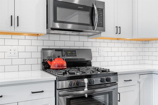 4263 Calder Dr, Marion, IA 52302 - kitchen featuring stainless steel appliances, decorative backsplash, white cabinets, and light stone countertops