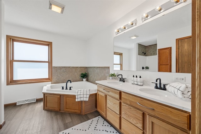 13294 212th Ave, Anamosa, IA 52205 - full bathroom featuring a bath, a shower, double vanity, and wood finished floors