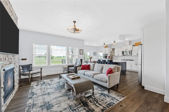 635 Deer Ridge Dr, Atkins, IA 52206 - living room with dark wood finished floors, a fireplace, a chandelier, and recessed lighting