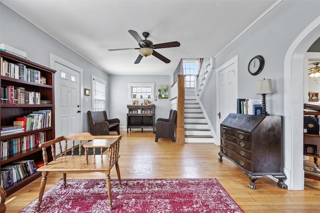 1812 Blake Blvd SE, Cedar Rapids, IA 52403 - living room with a ceiling fan, stairway, light wood finished floors, arched walkways, and ornamental molding