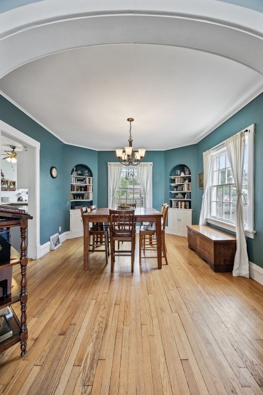 1812 Blake Blvd SE, Cedar Rapids, IA 52403 - dining space with built in shelves, healthy amount of natural light, light wood-style floors, and ornamental molding
