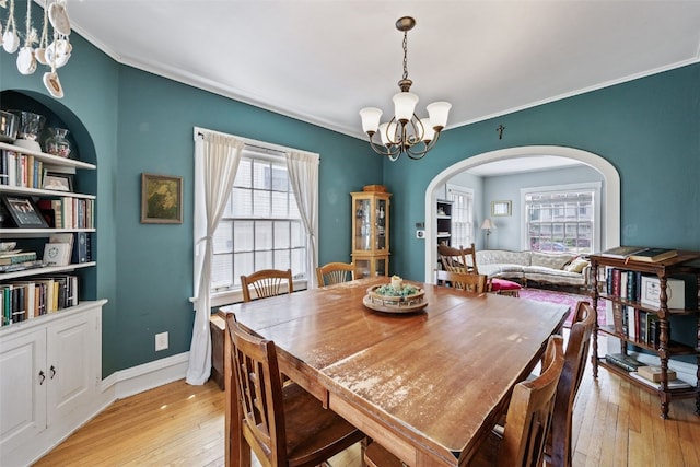 1812 Blake Blvd SE, Cedar Rapids, IA 52403 - dining space with a chandelier, arched walkways, light wood finished floors, crown molding, and built in features