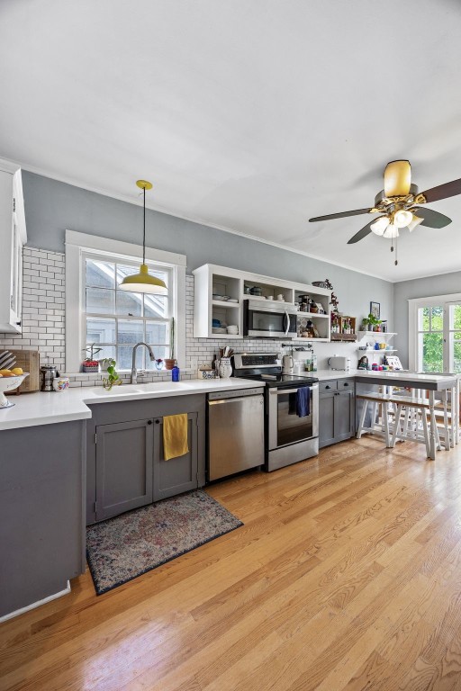 1812 Blake Blvd SE, Cedar Rapids, IA 52403 - kitchen with appliances with stainless steel finishes, gray cabinets, tasteful backsplash, light wood-style flooring, and a ceiling fan