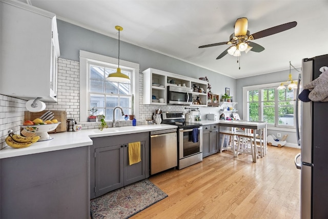 1812 Blake Blvd SE, Cedar Rapids, IA 52403 - kitchen with stainless steel appliances, gray cabinetry, light countertops, decorative backsplash, and light wood finished floors