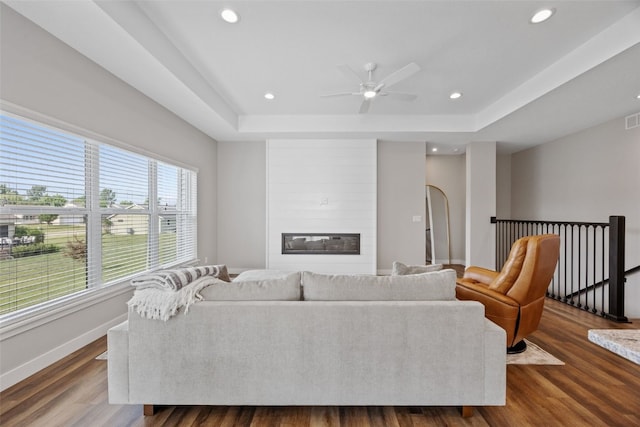 6415 Rookwood Ln, Marion, IA 52302 - living area with dark wood-type flooring, a tray ceiling, a large fireplace, ceiling fan, and recessed lighting