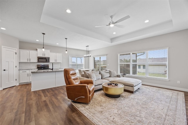 6415 Rookwood Ln, Marion, IA 52302 - living area with dark wood-type flooring, a raised ceiling, ceiling fan, recessed lighting, and a chandelier