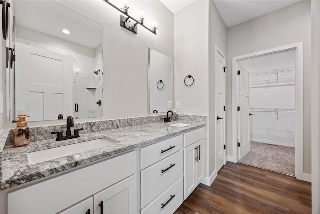 6415 Rookwood Ln, Marion, IA 52302 - bathroom featuring a shower stall, double vanity, wood finished floors, a walk in closet, and recessed lighting
