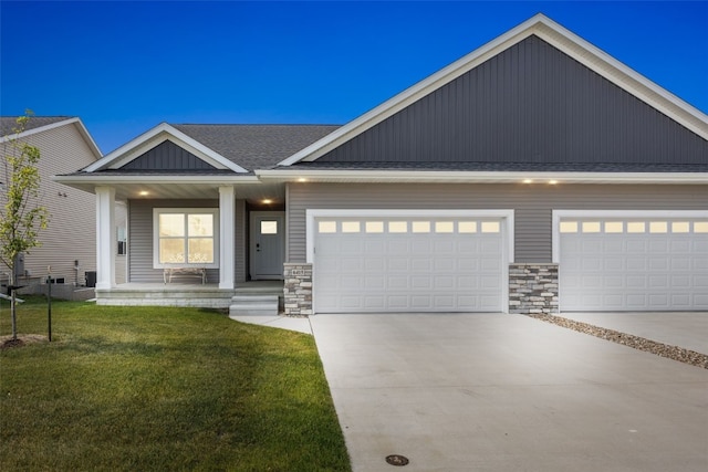 6415 Rookwood Ln, Marion, IA 52302 - view of front facade featuring covered porch, a front lawn, concrete driveway, stone siding, and an attached garage