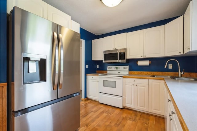 4531 Sugar Pine Dr NE, Cedar Rapids, IA 52402 - kitchen with appliances with stainless steel finishes, white cabinets, light wood-type flooring, and light countertops