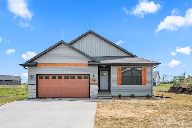 5007 Dostal Dr, Cedar Rapids, IA 52404 - view of front of house with an attached garage, concrete driveway, a front yard, board and batten siding, and roof with shingles