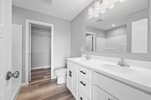 5007 Dostal Dr, Cedar Rapids, IA 52404 - full bath featuring double vanity, wood finished floors, a shower, and a walk in closet