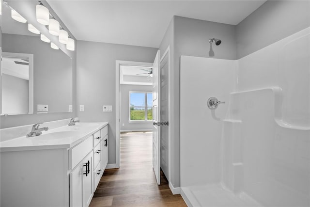 5007 Dostal Dr, Cedar Rapids, IA 52404 - full bathroom with ceiling fan, a shower, wood finished floors, and double vanity