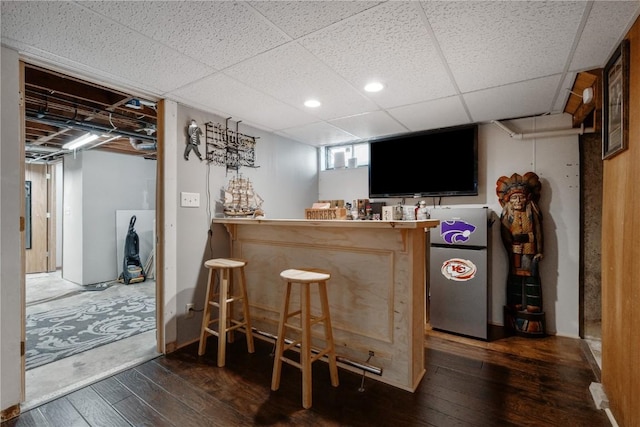 5515 Cedar Dr NW, Cedar Rapids, IA 52405 - indoor dry bar with hardwood / wood-style flooring, freestanding refrigerator, and a drop ceiling