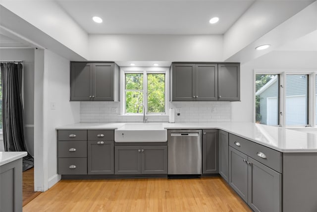 362 Garden Dr SE, Cedar Rapids, IA 52403 - kitchen featuring stainless steel dishwasher, gray cabinetry, light wood-type flooring, a peninsula, and light countertops
