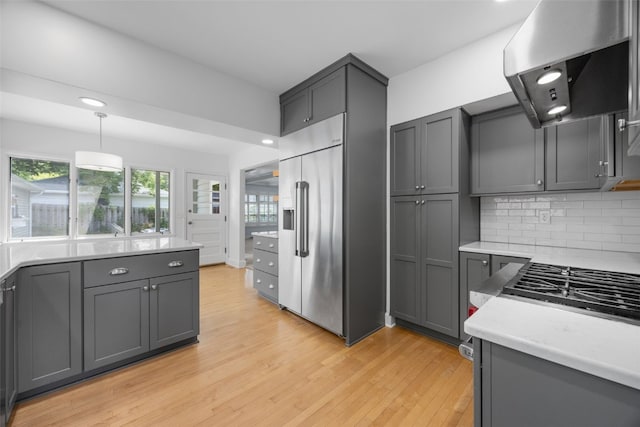 362 Garden Dr SE, Cedar Rapids, IA 52403 - kitchen with ventilation hood, high quality fridge, light wood finished floors, light countertops, and decorative backsplash