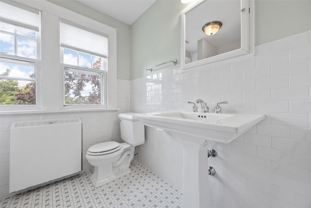362 Garden Dr SE, Cedar Rapids, IA 52403 - half bath featuring radiator, tile walls, tile patterned flooring, and a wainscoted wall