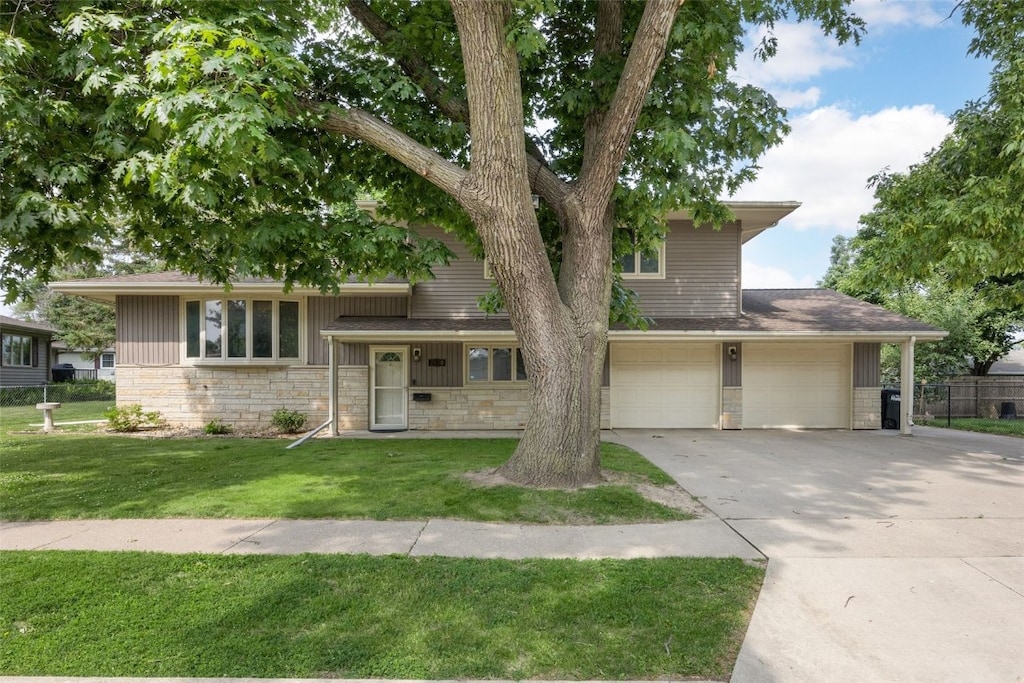 2030 26th St, Marion, IA 52302 - tri-level home featuring concrete driveway, a garage, and stone siding