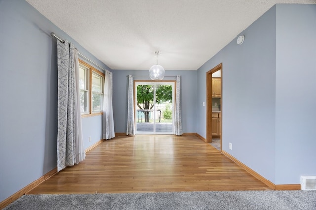 2030 26th St, Marion, IA 52302 - unfurnished dining area featuring light wood-style floors and a textured ceiling