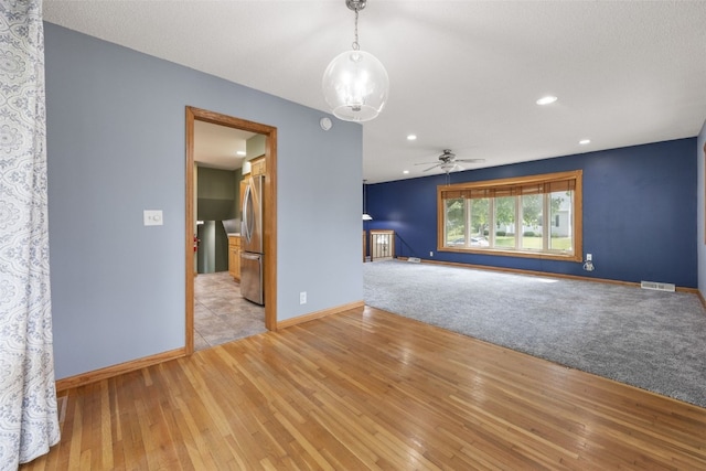 2030 26th St, Marion, IA 52302 - unfurnished living room with light wood-style flooring, a ceiling fan, recessed lighting, and a chandelier