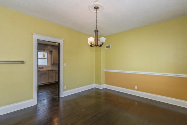 1346 11th St, Marion, IA 52302 - spare room featuring a chandelier and dark wood-style floors