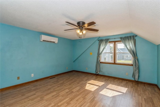 1346 11th St, Marion, IA 52302 - bonus room featuring a wall unit AC, wood finished floors, a textured ceiling, a ceiling fan, and vaulted ceiling