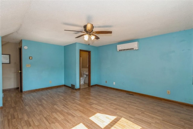 1346 11th St, Marion, IA 52302 - unfurnished room featuring an AC wall unit, wood finished floors, a ceiling fan, and a textured ceiling