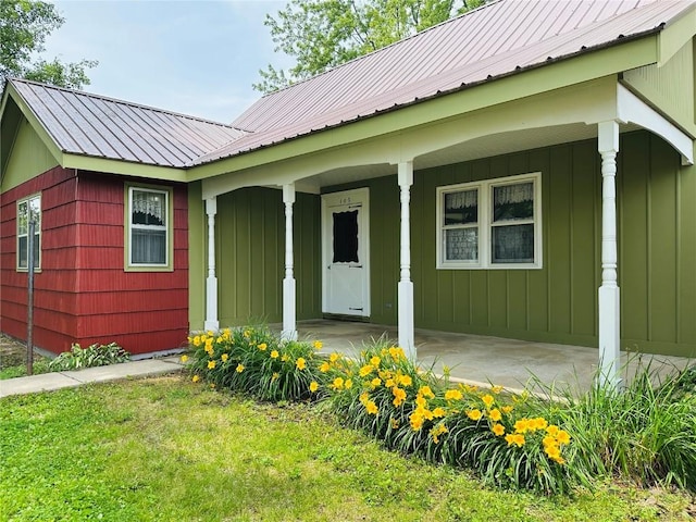 109 Pine St NW, Blairstown, IA 52209 - entrance to property with board and batten siding, a porch, and a metal roof