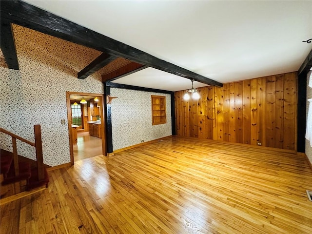 109 Pine St NW, Blairstown, IA 52209 - spare room with beamed ceiling, wood-type flooring, and wood walls