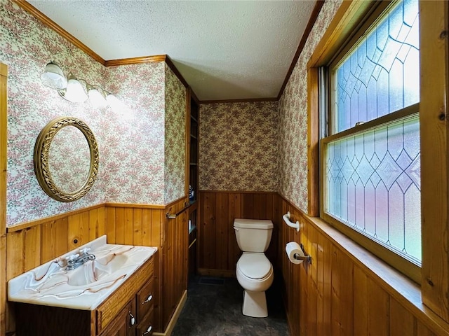 109 Pine St NW, Blairstown, IA 52209 - bathroom featuring a wainscoted wall, wallpapered walls, a textured ceiling, ornamental molding, and vanity