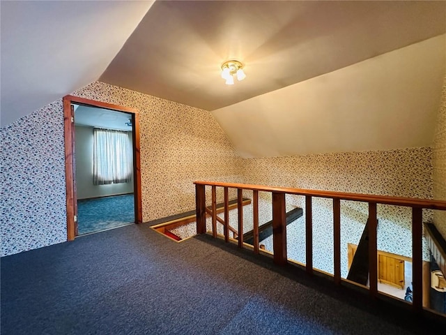 109 Pine St NW, Blairstown, IA 52209 - additional living space featuring wallpapered walls, vaulted ceiling, and carpet flooring