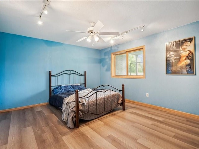 3387 64th St, Palo, IA 52324 - bedroom featuring rail lighting, wood finished floors, and ceiling fan