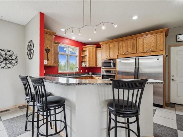 3387 64th St, Palo, IA 52324 - kitchen with stainless steel appliances, a kitchen breakfast bar, light tile patterned floors, and recessed lighting