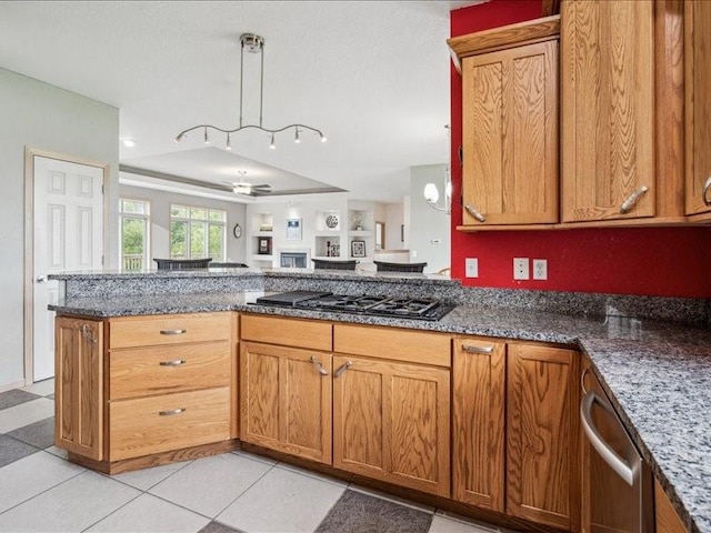 3387 64th St, Palo, IA 52324 - kitchen featuring appliances with stainless steel finishes, a ceiling fan, brown cabinetry, dark stone countertops, and a peninsula