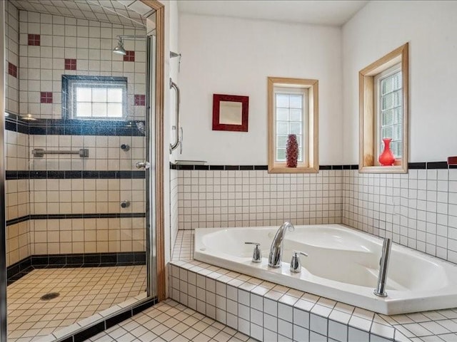 3387 64th St, Palo, IA 52324 - bathroom featuring a stall shower, a bath, tile patterned floors, and wainscoting