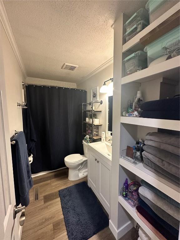 6706 Boxwood Ln NE, Cedar Rapids, IA 52402 - bathroom with ornamental molding, a textured ceiling, vanity, wood finished floors, and curtained shower
