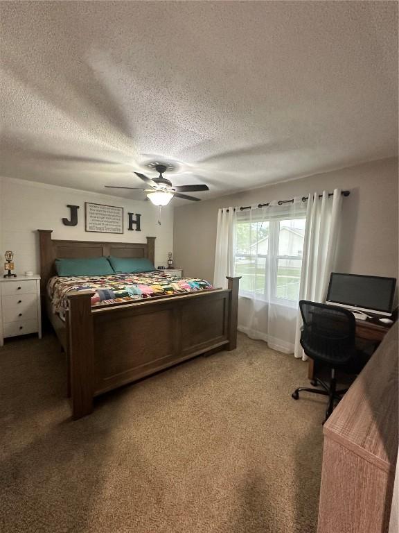 6706 Boxwood Ln NE, Cedar Rapids, IA 52402 - carpeted bedroom with a textured ceiling, a desk, and a ceiling fan