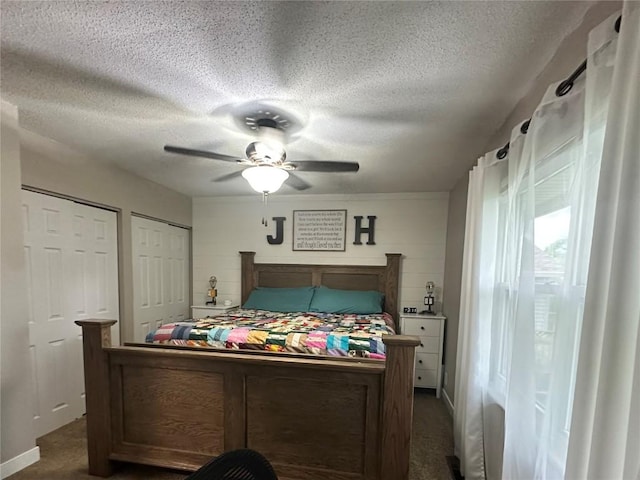6706 Boxwood Ln NE, Cedar Rapids, IA 52402 - bedroom featuring multiple closets, dark carpet, a textured ceiling, and a ceiling fan