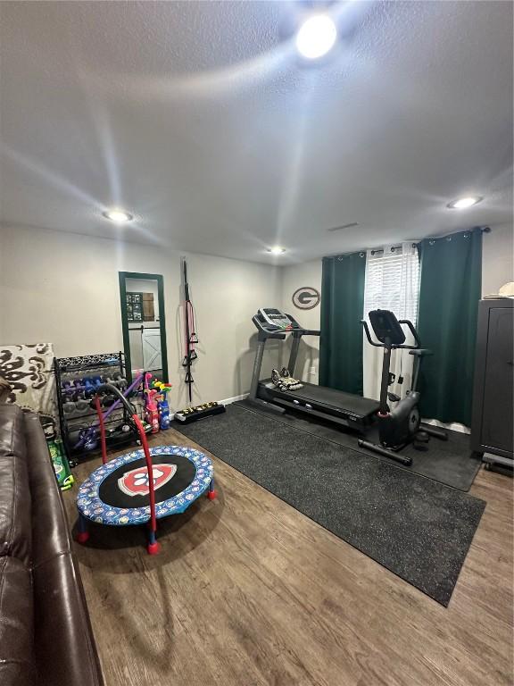 6706 Boxwood Ln NE, Cedar Rapids, IA 52402 - exercise room featuring a textured ceiling and wood finished floors