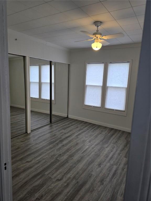 314 Main St, Oxford Junction, IA 52323 - unfurnished bedroom featuring dark wood-style floors and ceiling fan