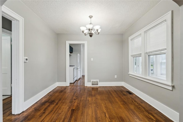 1612 Greene Ave NE, Cedar Rapids, IA 52402 - unfurnished dining area with a chandelier, a textured ceiling, and dark wood-style floors