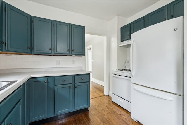1612 Greene Ave NE, Cedar Rapids, IA 52402 - kitchen featuring white appliances, dark wood-style flooring, decorative backsplash, light countertops, and blue cabinets