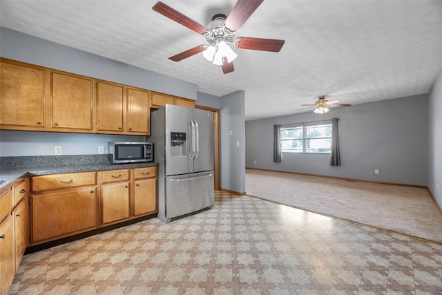 203 B Ave, Newhall, IA 52315 - kitchen with appliances with stainless steel finishes, light flooring, a ceiling fan, dark countertops, and brown cabinets