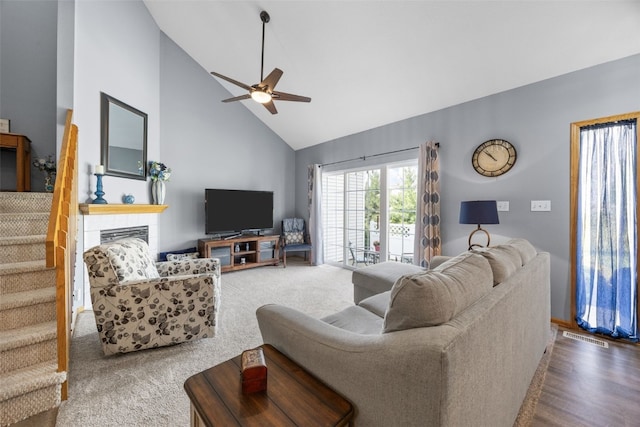 3810 Waterview Ct SW, Cedar Rapids, IA 52404 - living room with high vaulted ceiling, a ceiling fan, a tile fireplace, stairs, and carpet