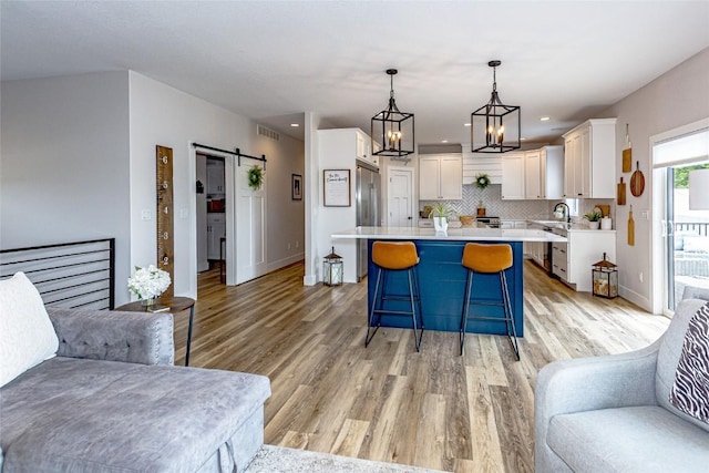 608 Pointer Cir, Center Point, IA 52213 - kitchen with light countertops, white cabinetry, a breakfast bar, light wood-style floors, and recessed lighting