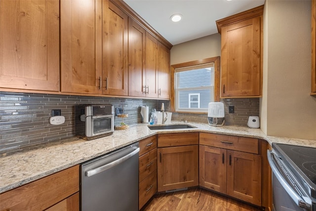 908 18th St SW, Cedar Rapids, IA 52404 - kitchen with appliances with stainless steel finishes, brown cabinetry, decorative backsplash, and recessed lighting