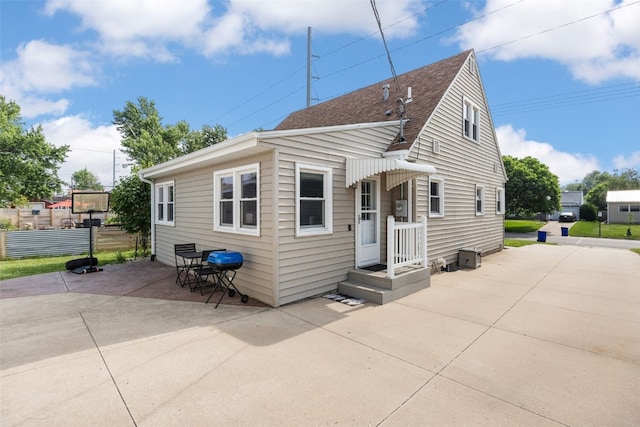908 18th St SW, Cedar Rapids, IA 52404 - back of property featuring a shingled roof and a patio