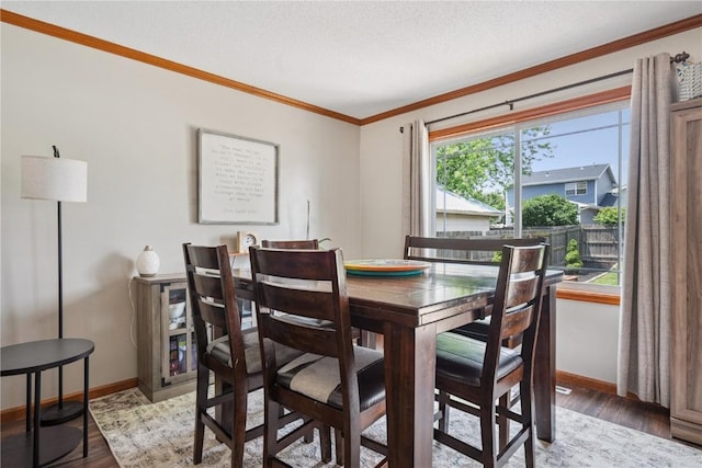 3210 5th St, Marion, IA 52302 - dining space featuring crown molding, light wood-type flooring, and a textured ceiling
