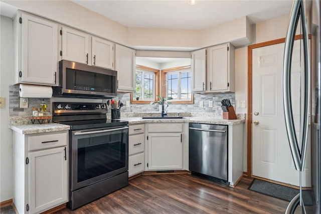 3210 5th St, Marion, IA 52302 - kitchen featuring stainless steel appliances, backsplash, dark wood finished floors, and white cabinetry
